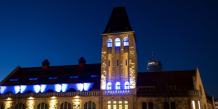 In Blau und Gelb angestrahltes schlossähnliches Gebäude  ©JenaKultur, C. Worsch