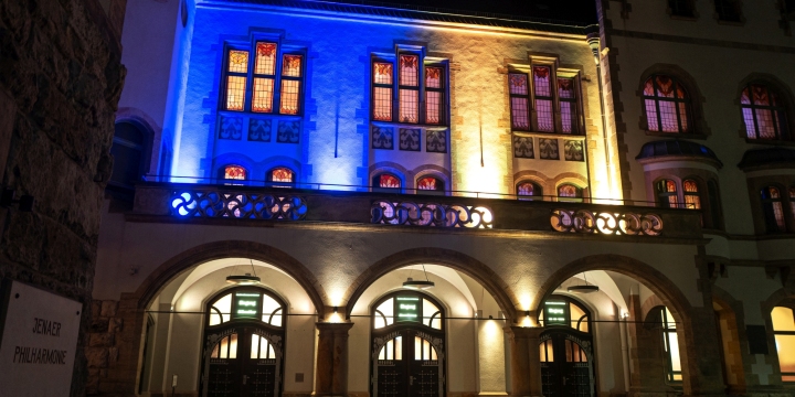 In Gelb und Blau angestrahltes Portal des Volkshaus Jenas  ©JenaKultur, C. Worsch